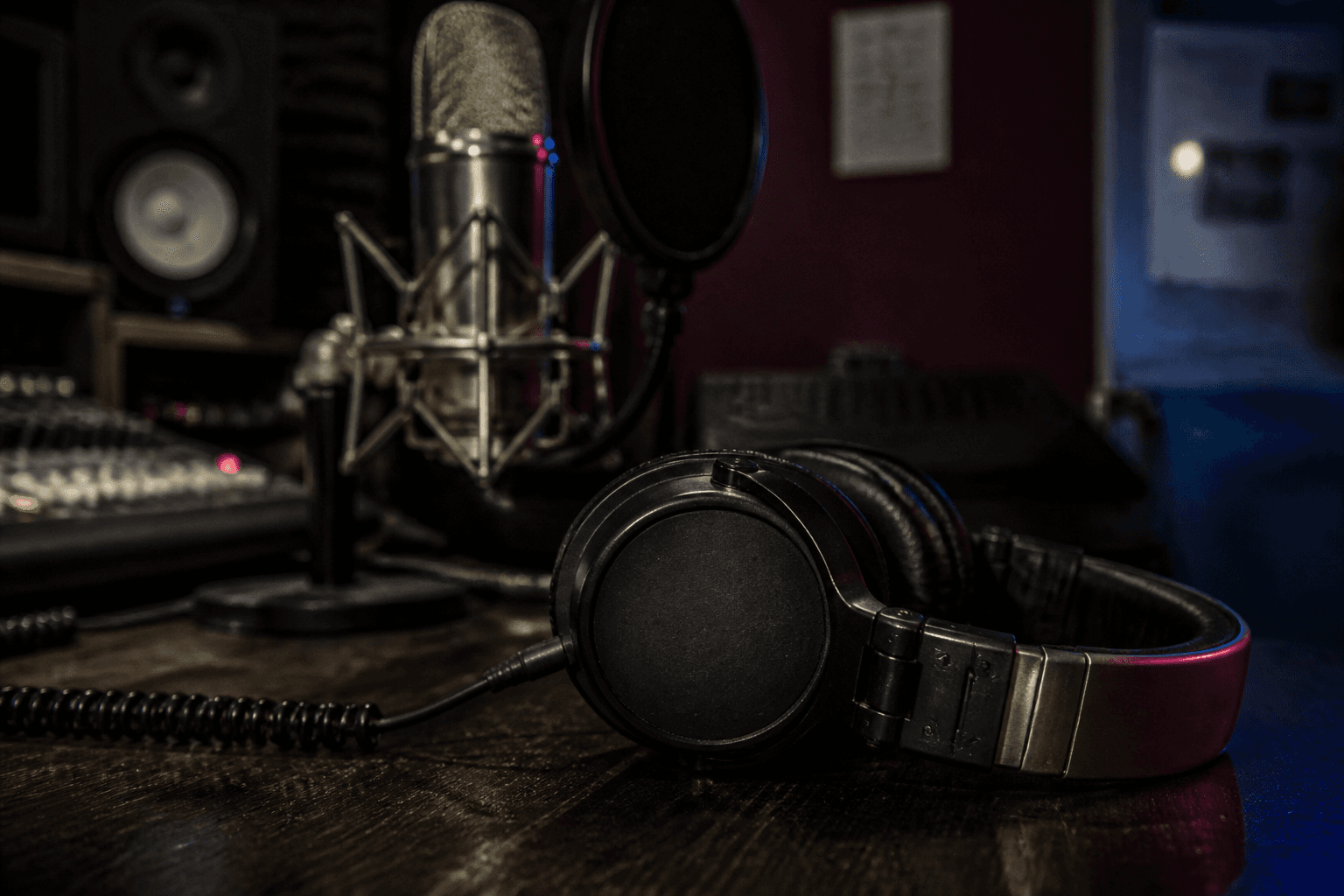 Studio headphones resting beside a recording microphone